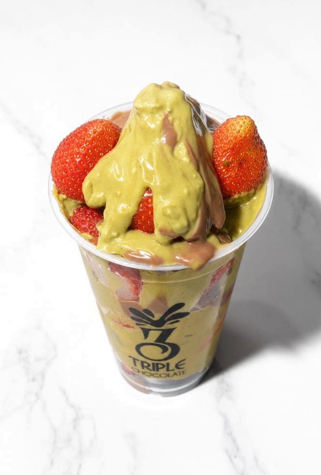 Strawberry Dubai chocolate cup with pistachio chocolate over fresh strawberries
